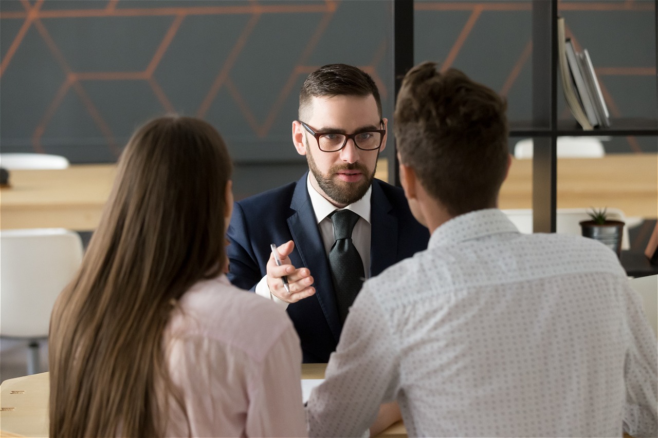 Hombre de traje hablando con pareja